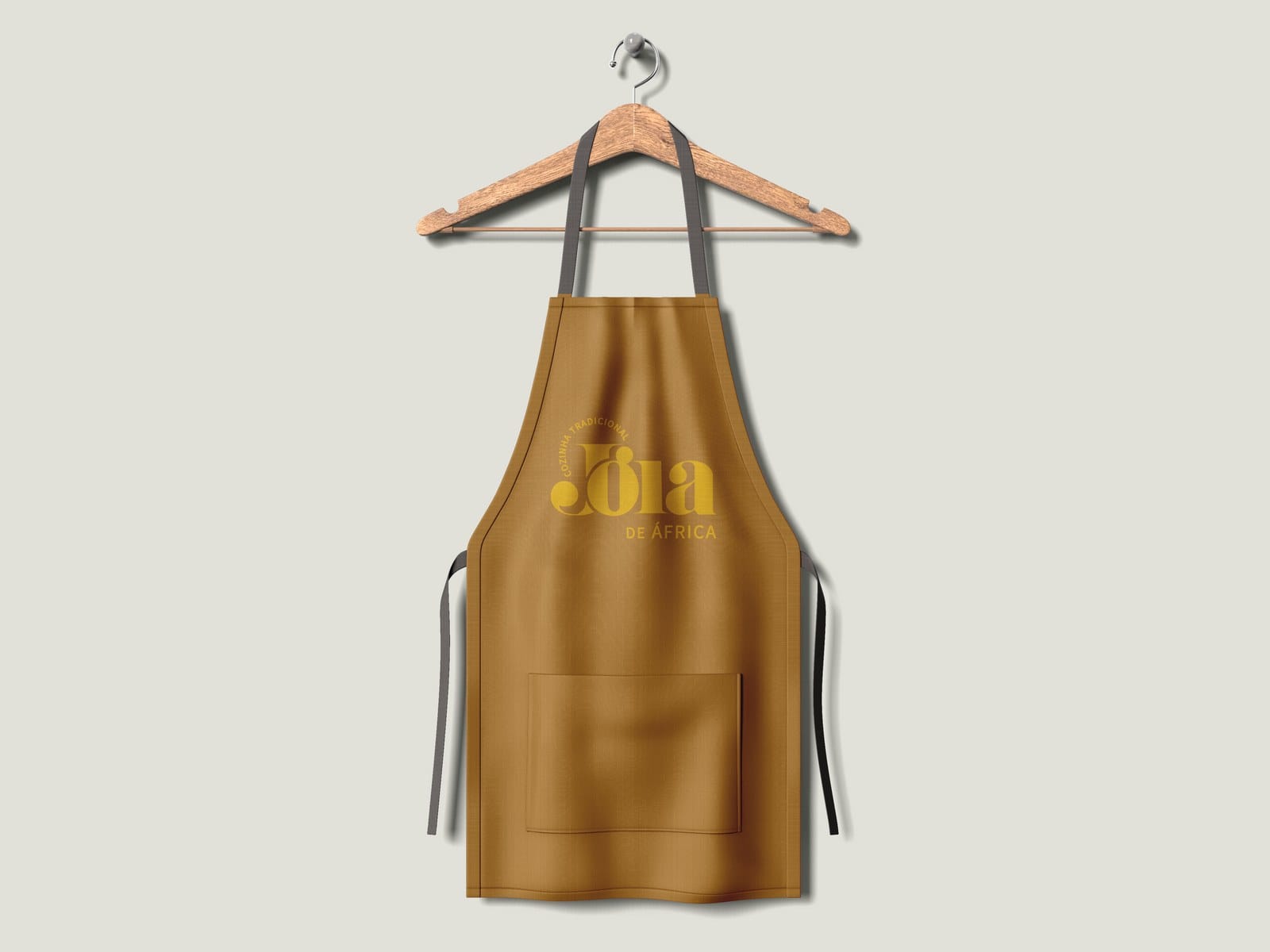 Ochre apron with the Jóia logo on a hanger