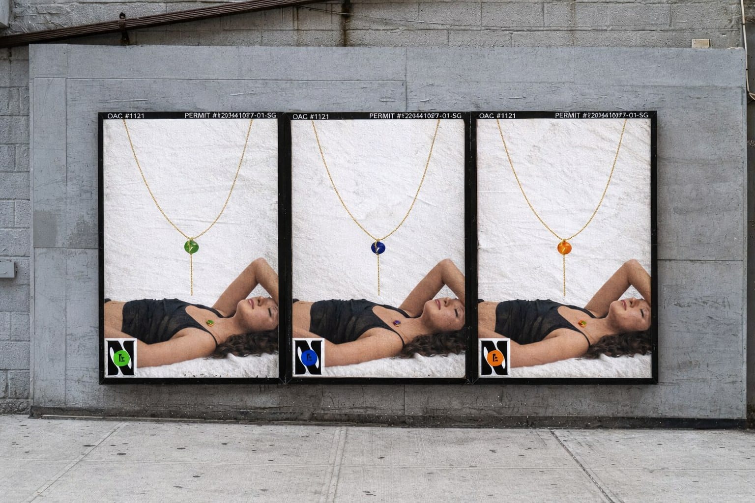 Mockup: three posters on a concrete wall, each with a woman lying down and a necklace in a different gem colour