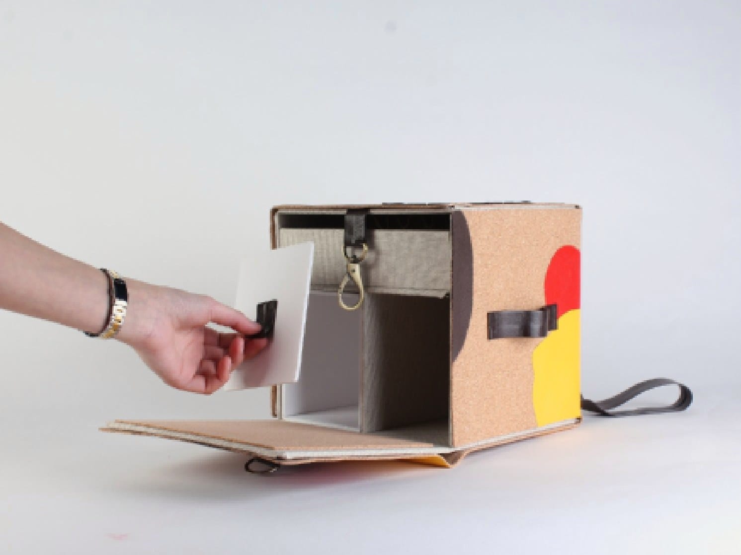 A hand sliding a panel out of the open prototype